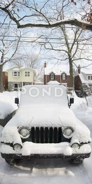 Snow Covered Jeep In Driveway