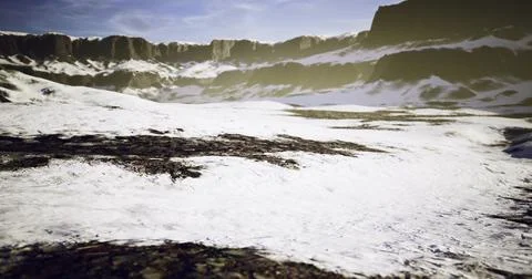 Snow covered landscape with rugged mountains under bright sky Ilustração Stock