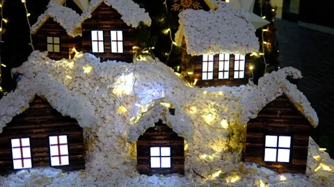 Snow-covered mini cabins glow with festive lights Stock Footage 327716955