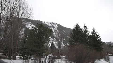 Snow covered mountain and river passing through green forest during winter Stock Footage 84505563