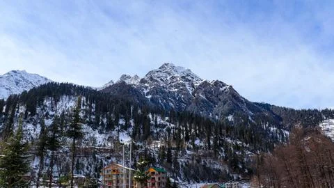 Snow-covered mountain in the background with mountain covered with pine trees Fotos de archivo