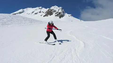 Snow covered mountain with beginner skier making graceful turns under clear sky Video stock 323122246