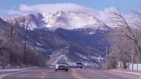 Snow covered mountain with fast moving cars on a highway in the foreground Stock Footage 229438533