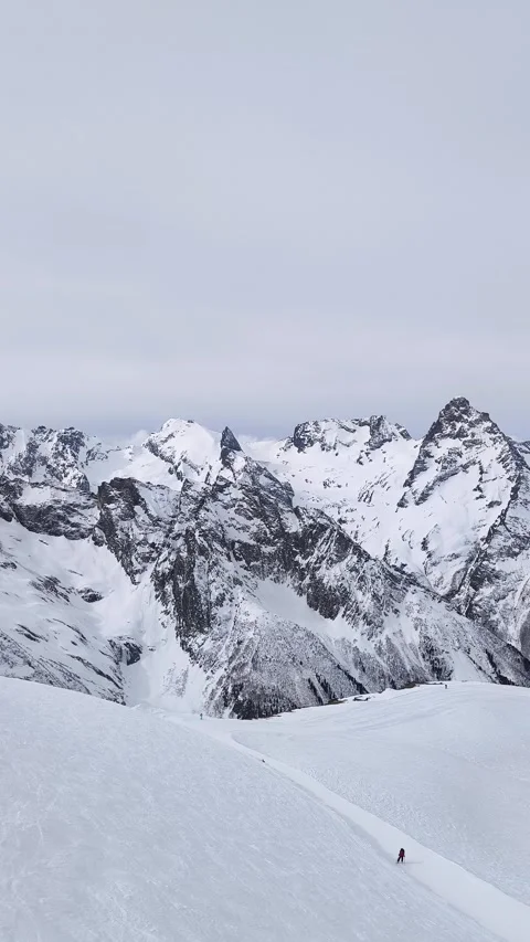 Snow-covered mountain landscape with rugged peaks and a clear sky Stock Footage 327653373