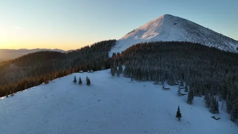 Snow-covered mountain landscape at sunset with serene forest views in winter. Stock Footage 293826427