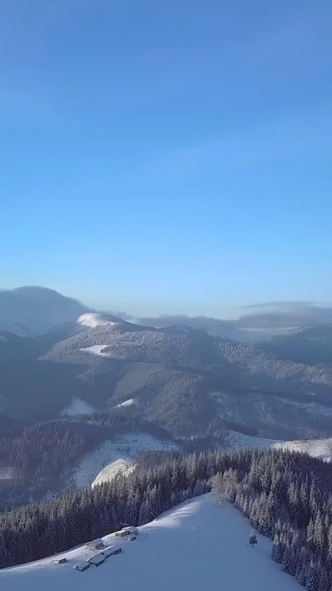 Snow-covered mountain landscape under a clear blue sky in winter Stock Footage 293679363