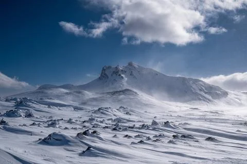 Snow-covered mountain landscape under a cloudy sky Foto stock