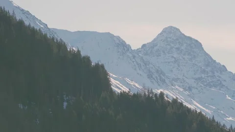 A snow-covered mountain peak against a blue sky above Davos Stock Footage 345299400