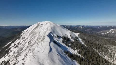 Snow-covered mountain peak with clear blue skies and breathtaking landscapes Stock Footage 293826063
