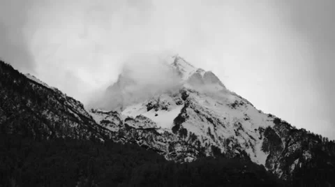 Snow-covered mountain peak enveloped in mist Stock Footage 61071762