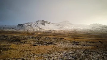 Snow covered mountain pullin over a greenish field Video stock 85523628