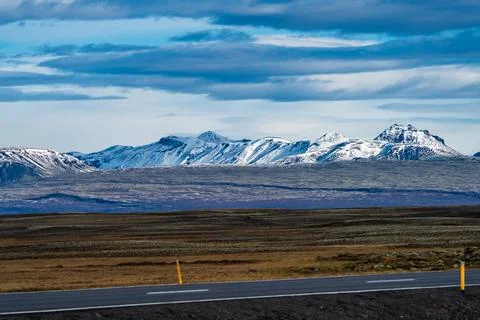Snow covered mountain range and road under the clouds Foto stock