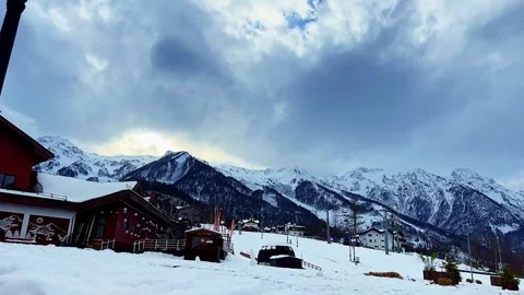 A snow covered mountain range is in the background of a building 스톡 동영상 274835820