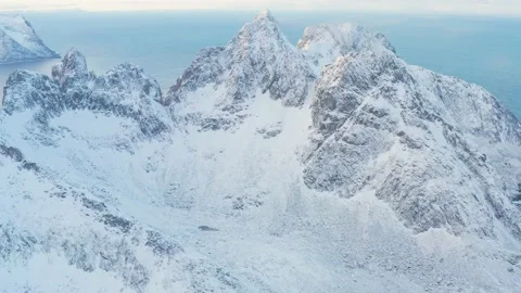 Snow covered mountain range on coastline in winter, Norway. Senja Stock Footage 234550392