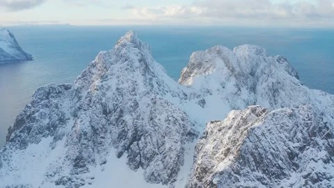 Snow covered mountain range on coastline in winter, Norway. Senja Stock Footage 234550839