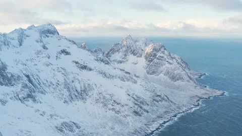 Snow covered mountain range on coastline in winter, Norway. Senja Stock Footage 234550867