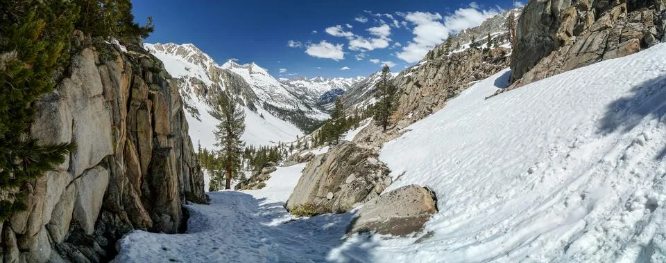 A snow covered mountain range with a path leading to the top Stock Photos