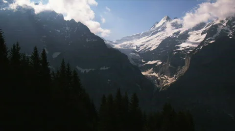 Snow covered mountain range with pine trees in the foreground Stock Footage 750242
