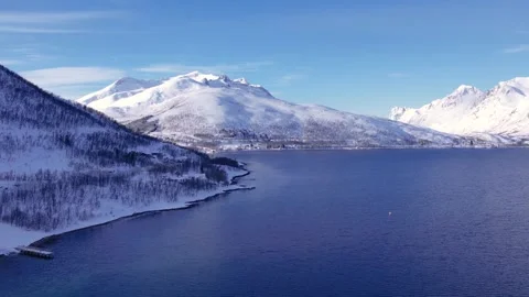 Snow covered mountain range on winter coastline Norway. Troms county Fjordgard Stock Footage 253490137