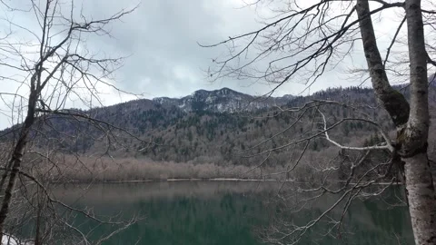 Snow-covered mountain ridges behind a blue mountain lake. Stock Footage 317633800
