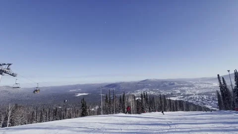 A snow-covered mountain winter forest with a ski lift at a ski resort. Видео 321563159