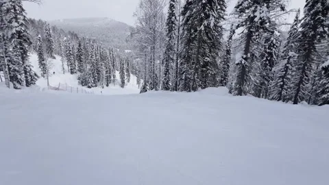 A snow-covered mountain winter forest with a ski lift at a ski resort. Видео 321563371