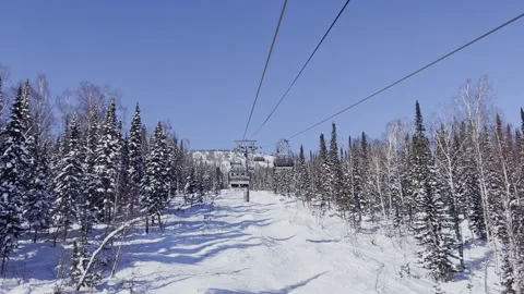 A snow-covered mountain winter forest with a ski lift at a ski resort. Видео 321563706