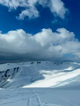 Snow-covered mountains and clouds in the sky during winter in the Alps show.. Stock Photos