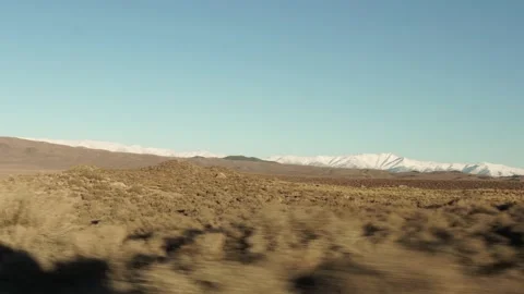 Snow Covered Mountains with Field in Foreground at Golden Hour, Gimbal Stock Footage 145464371