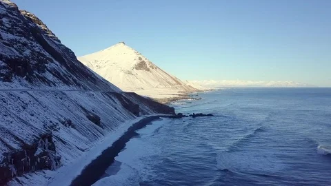 Snow covered mountains by ocean in bright sunny day. Stock Footage 86565571
