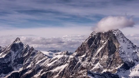 Snow covered mountains surrounded by clouds during daytime Stock Footage 77803039
