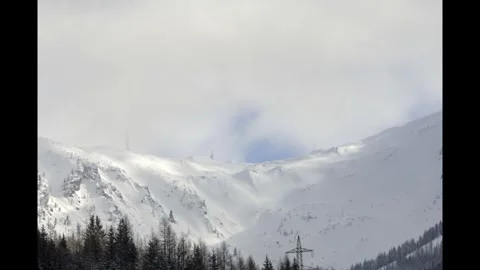 Snow-Covered Mountains Under Cloudy Sky Stock Footage 303867474