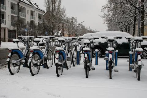 Snow-Covered MVG Shared Bikes Parked at Bike Stand in Munich, Germany Stock Photos