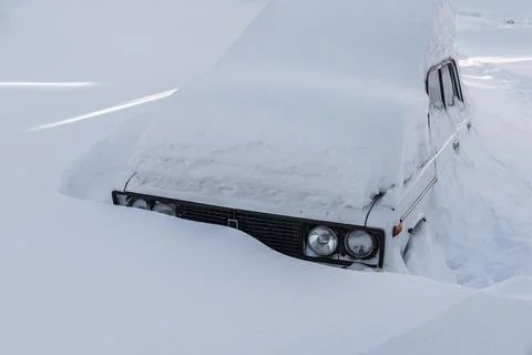 Snow covered passenger car on a winter road Stock Photos