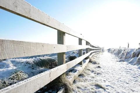 Snow covered path on cliff edge fenced walk Stock Photos