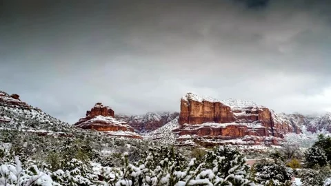 Snow-Covered Red Rock Formations Under Cloudy Sky Stock Footage 311491012