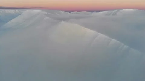 Snow-covered ridge of the mountain range in the clouds at sunset. Gentle evening Video stock 154610697