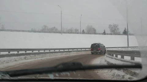 Snow-covered road and forests from the car window. winter trail is dangerous Stock Footage 146304591