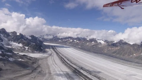 Snow covered road between rocky mountain on a sunny day Video stock 100172259
