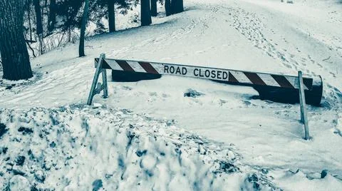 Snow covered road closedown with footprints around Stock Photos