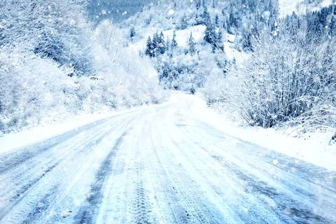 Snow covered road in the mountains on snowy day Stock Photos
