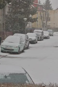 Snow-covered road, wheel marks in the snow and snow-covered cars during heavy Stock Photos