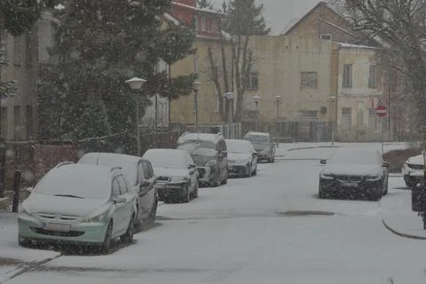 Snow-covered road, wheel marks in the snow and snow-covered cars during heavy Stock Photos
