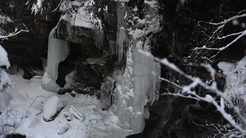Snow-covered rocks and flowing river in a tranquil winter landscape Stock Footage 290785677