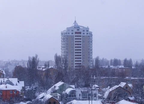 Snow-covered roofs of private houses and a multi-storey building Stock Photos