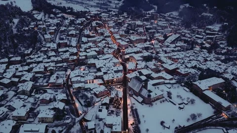 Snow-covered Rooftops and Winding Streets Glow at Dusk in Cavalese, Set in Val Video stock 328749449