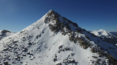 Snow Covered Rugged Mountain Peak Aerial Pull Away, Colorado Stock Footage 101623328