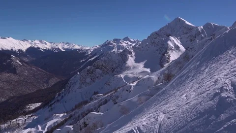 Snow-covered slope with ski and snowboard tracks in Caucasus mountains. Krasnaya Stock Footage 80286450