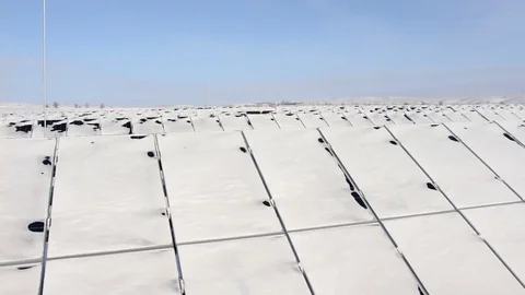 Snow-covered solar panels pan right Stock Footage 72434918