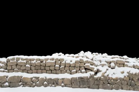 Snow covered stone wall isolated on black background Stock Photos